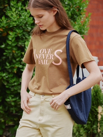 LOVE NEVER FAILS T SHIRT - BROWN